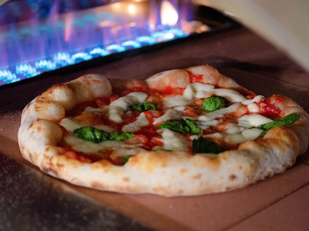 Neapolitan margherita pizza baking on the firebrick floor of an Alfa oven